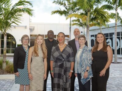 Image of CFLeads staff members in front of the Collaboratory in Florida. Palm trees and a building are present.